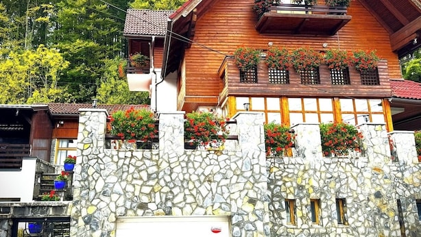 A traditional wooden chalet with stone walls and flower boxes on the balconies. - Villa Alisio w. Sauna, Jacuzzi, Gym, BBQ (Sinaia)