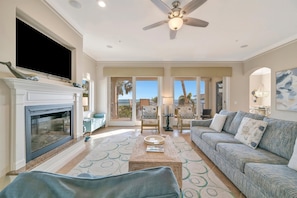 A living room with a fireplace, sofa, and a ceiling fan.