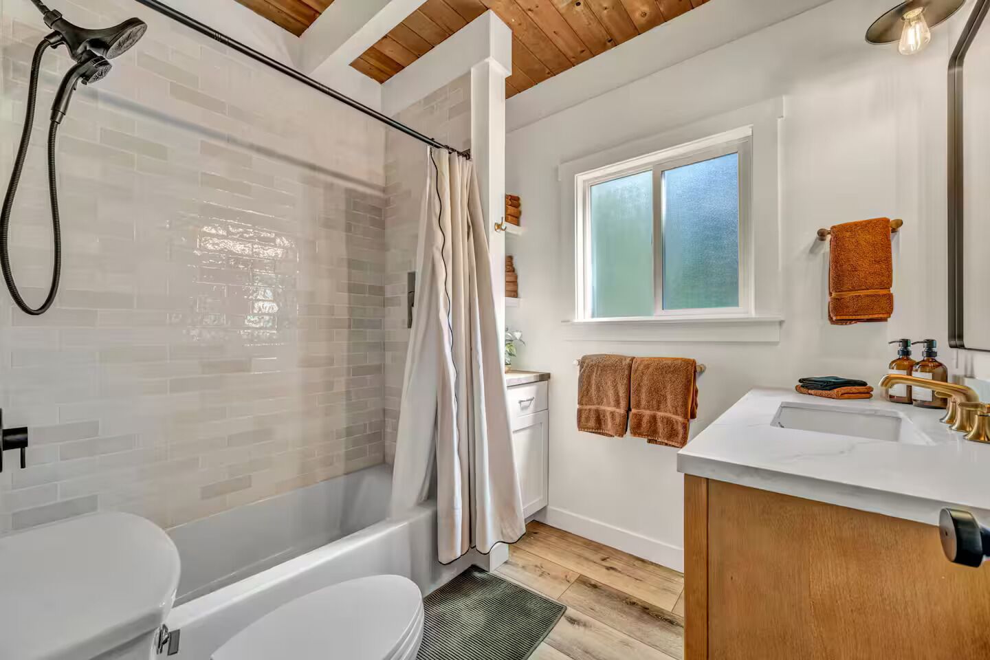 Une salle de bain avec douche, toilettes et lavabo.
