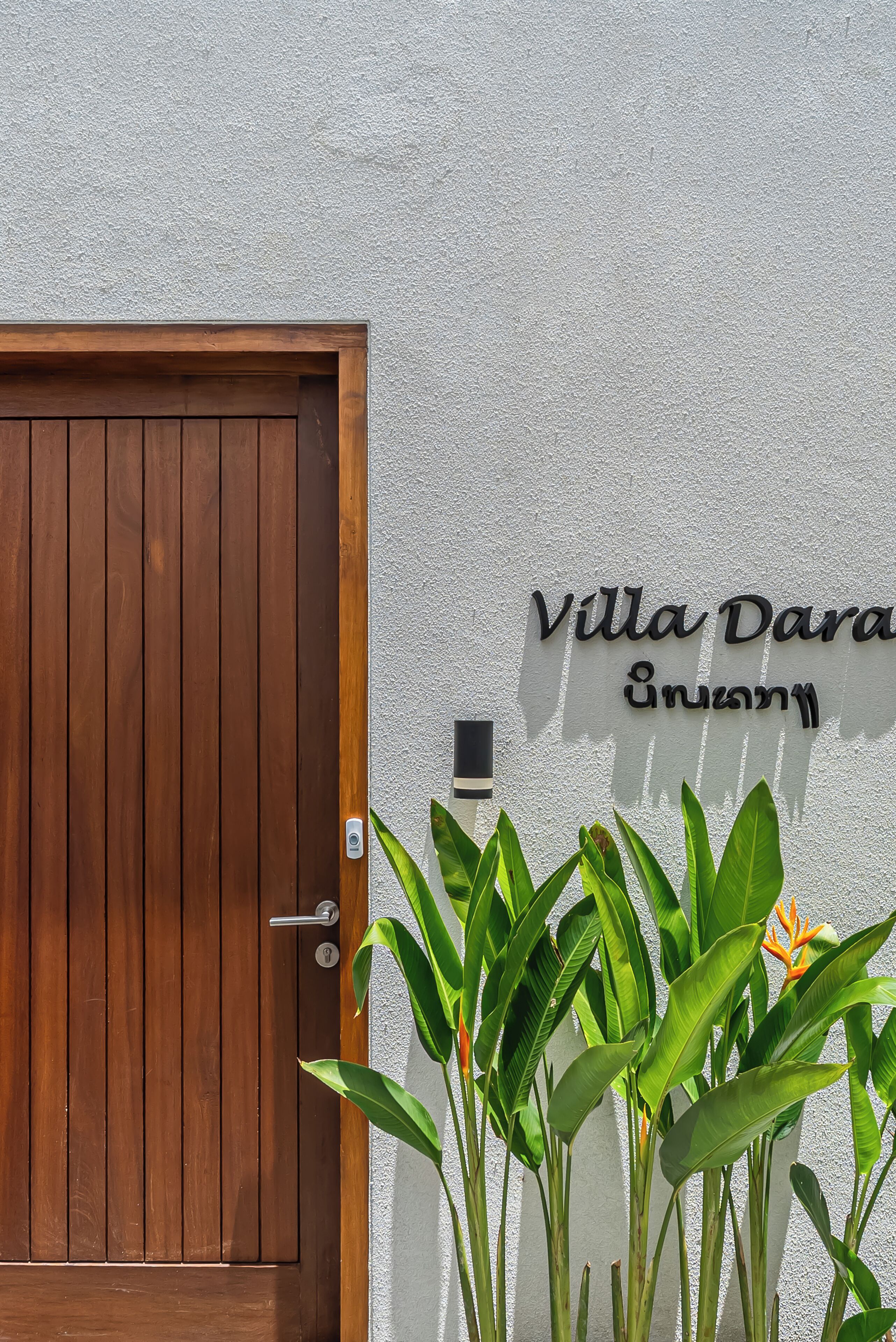 A wooden door with a keyhole and a wall-mounted sign reading "Villa Dara".