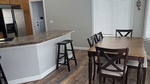 Une cuisine moderne dotée d’un îlot central, d’une table à manger en bois et de chaises.