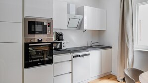 A compact kitchen with a built-in microwave, oven, and coffee maker. - Blueground | Wieden, washer/dryer, nr Karlskirche (Vienna)