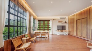 A spacious room with large windows, a dining area, and a television. - Harley 1 BDR Condo Kata Hill, 3 Mins To kata Beach (Karon)