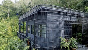 A modern, curved building with a metal exterior, surrounded by lush greenery. - Harley 1 BDR Condo Kata Hill, 3 Mins To kata Beach (Karon)