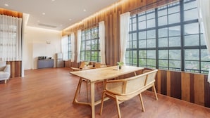 A spacious room with a wooden dining table, wicker chairs, and large windows offering a view of greenery. - Harley 1 BDR Condo Kata Hill, 3 Mins To kata Beach (Karon)