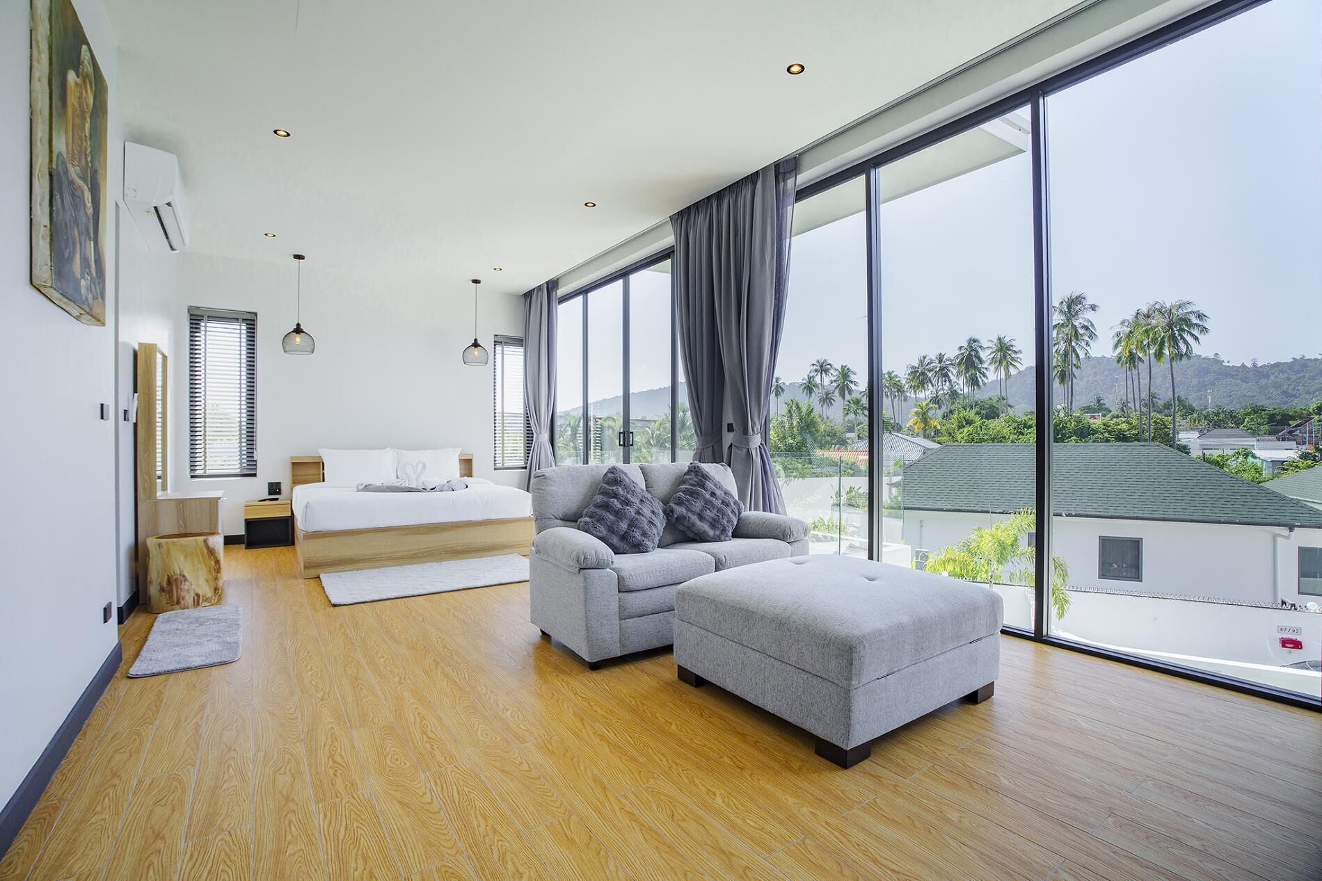 Ein modernes Schlafzimmer mit großem Fenster, einer Couch und einem Bett.