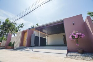 A modern building with a covered entrance, a potted plant, and a clear sky. - New Celine Villa Private Pool Near Beaches (Rawai)