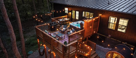 Eine Holzhütte mit Terrasse, Sitzgelegenheit im Freien und einem Whirlpool.