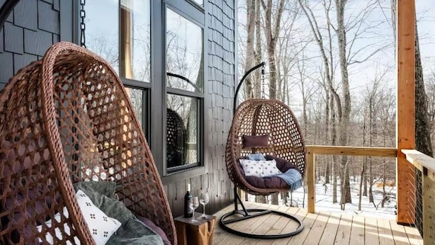 A cozy outdoor seating area with wicker chairs and a wooden deck.