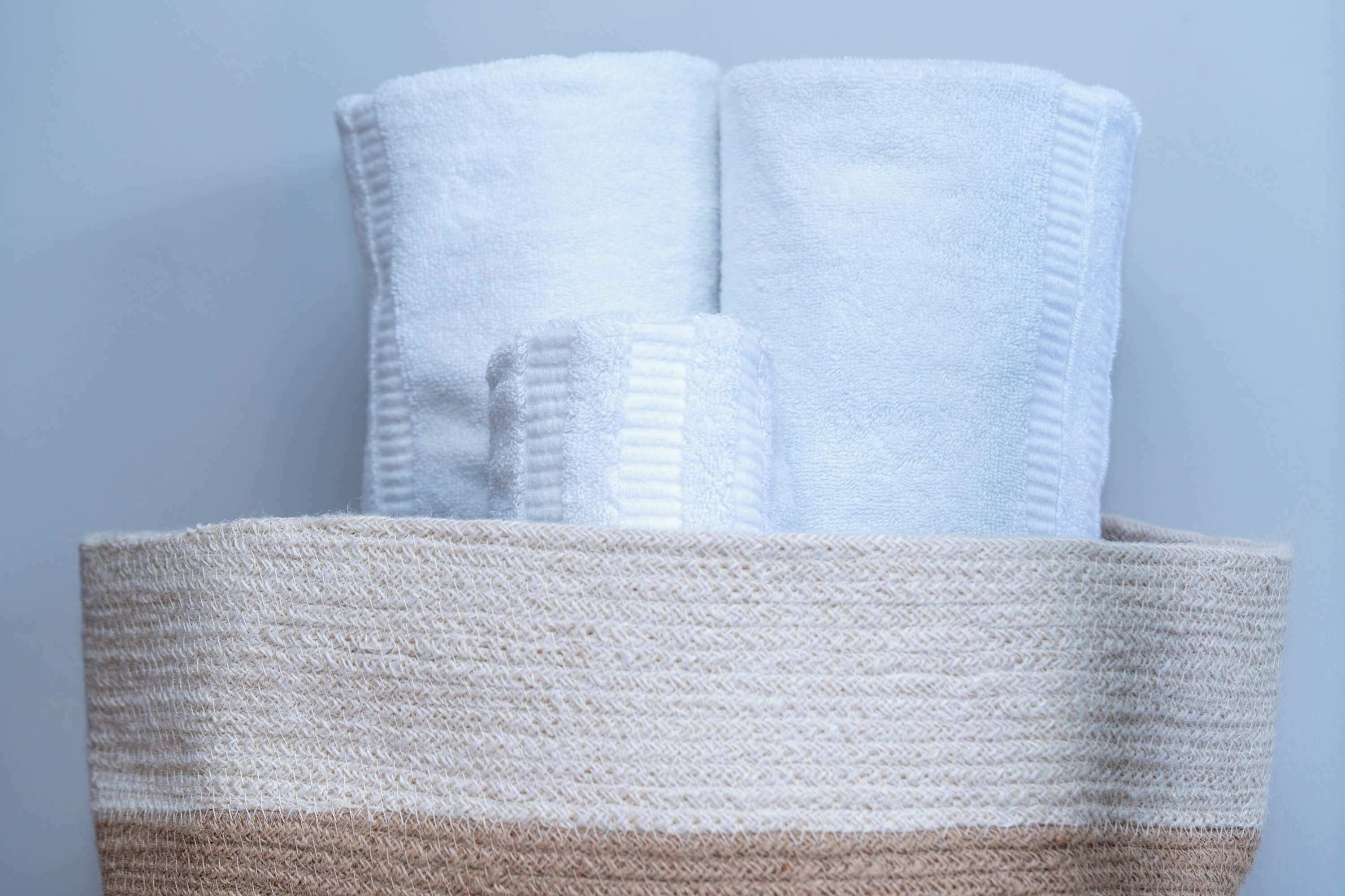 A basket containing folded white towels.