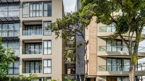 A modern multi-story building with balconies, large windows, and a mix of glass and concrete facades. - Deluxe Nomad Pad In Granada | Walk Anywhere | 302 (Cali)