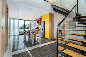 A modern kitchen with a dining area, a staircase, and a view of the city. - Deluxe Two-Story Penthouse • Amazing Granada | 402 (Cali)