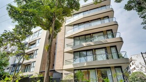 A multi-story residential building with balconies, large windows, and a modern architectural design. - Deluxe 2-Bed • By Cali's Best Restaurants | 301 (Cali)