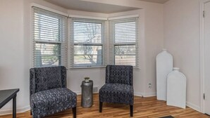 A corner room with two patterned chairs, a small table, and a decorative vase. - Perfect 2-bedroom apartment near McKennan Park and Downtown! (Sioux Falls)