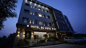 A multi-story hotel with a modern design, featuring a prominent entrance, a restaurant, and a parking area. - Hotel RS (Agra)