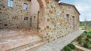 A stone building with a brick pathway and a small garden area. - 2 bedroom awesome apartment in Trequanda (Trequanda)