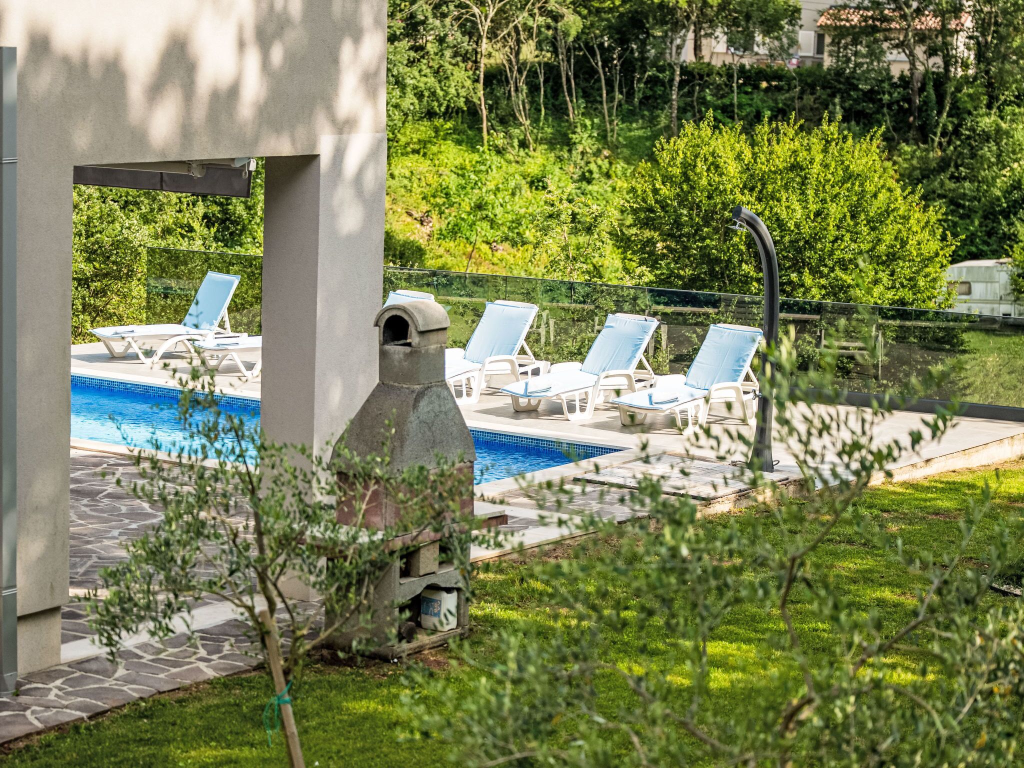 Un espace piscine avec des chaises longues et une structure en pierre.