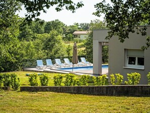 A pool area with lounge chairs and a building in the background. - mit eigenem Pool by Interhome (Drenje)