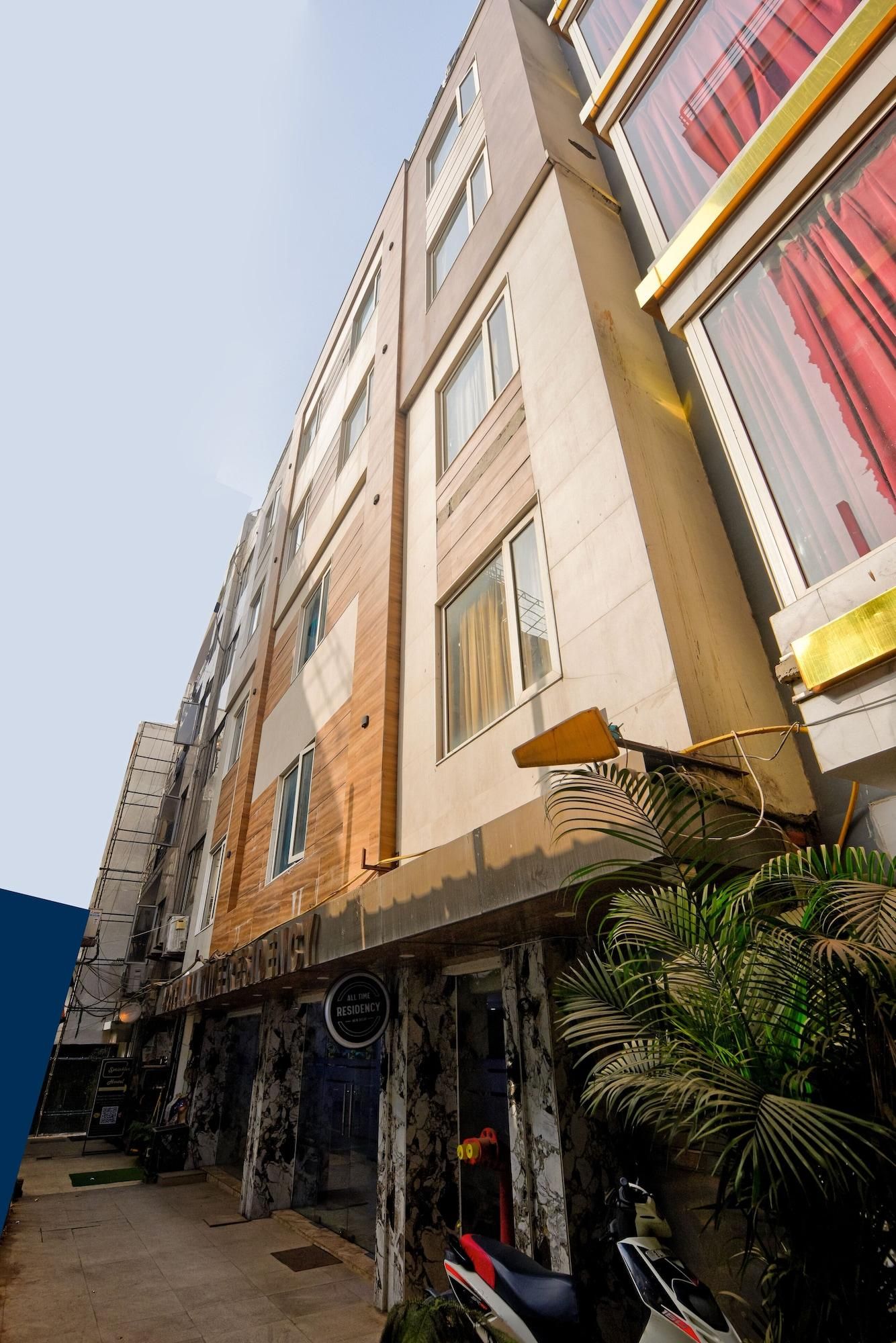 Un edificio de varios pisos con fachada moderna, ventanas amplias y un cartel que indica que es una residencia.