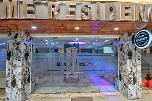 A hotel entrance with a marble facade, a glass door, and a sign indicating 'ALL TIME RESIDENCY NEW DELHI'. - Hotel All Time Residency New Delhi (New Delhi)