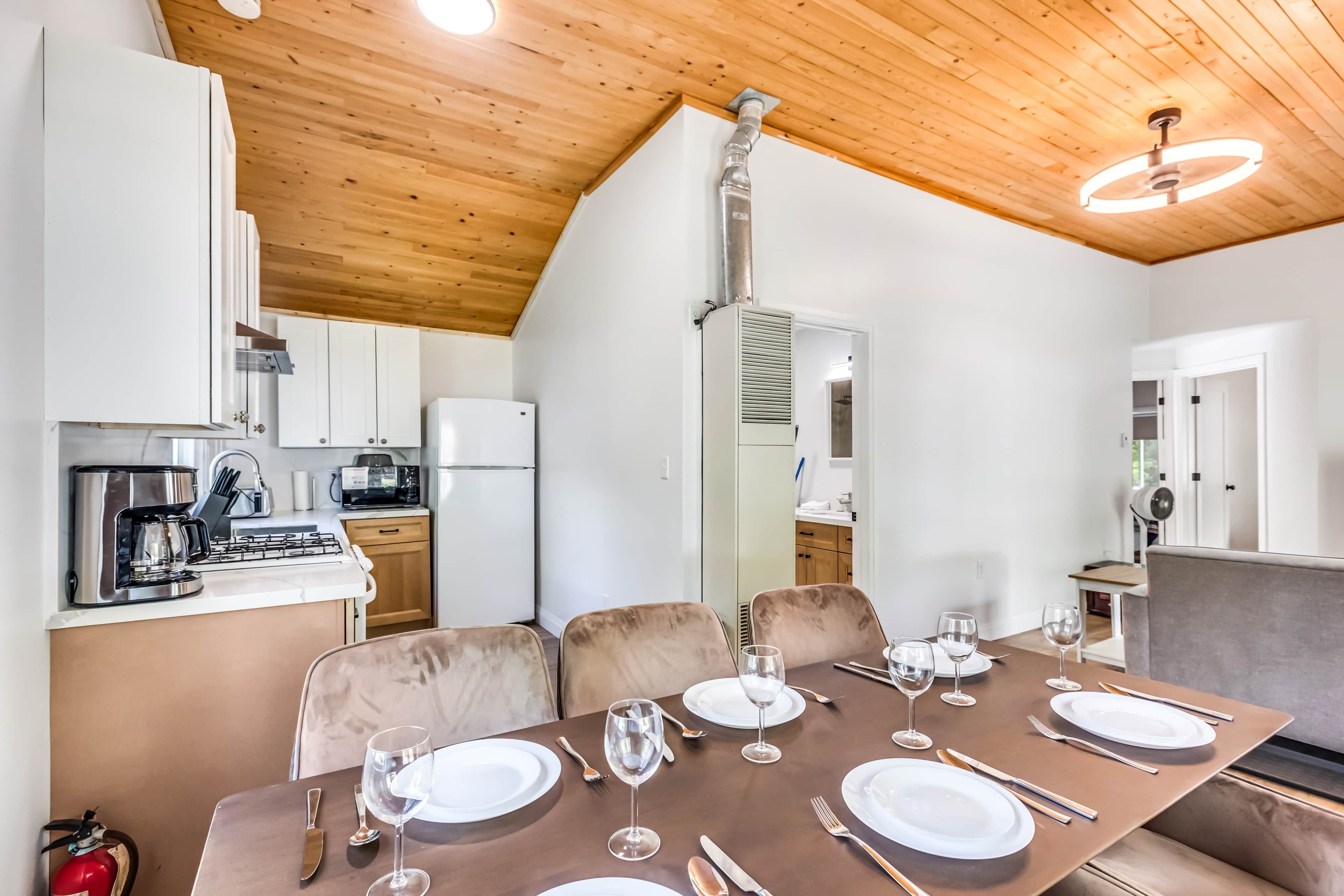 A modern kitchen with white cabinets, a stainless steel coffee maker, and a built-in microwave.