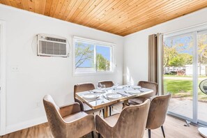 A dining area with a wooden ceiling, a large window, and a view of the outdoors. - #5 Cottage - Sri Lanka (Hamilton)