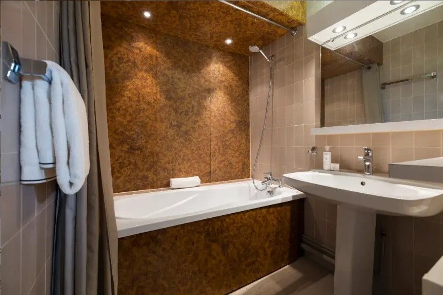 A modern bathroom with a bathtub, a sink, and a mirror.