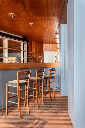 A bar area with wooden chairs and a bar counter. - Crystal Hôtel Courchevel (Les Allues)