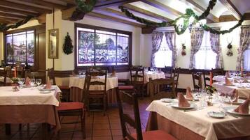 Ein Restaurant mit mehreren Essplätzen und Blick durch große Fenster.