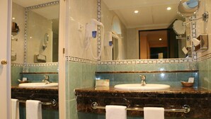 Un baño con dos lavamanos, un perchero y un espejo.