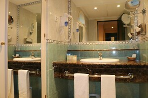 Un baño con dos lavamanos, un perchero y un espejo.