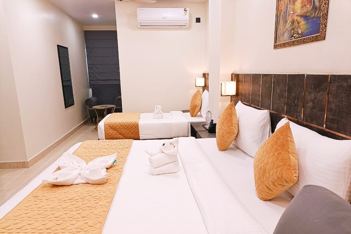 A hotel room with two beds, a dark headboard, and a painting on the wall.