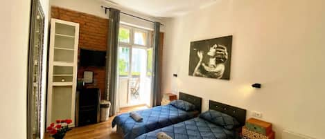 Quarto com duas camas, um candelabro, um quadro e vista para o exterior.