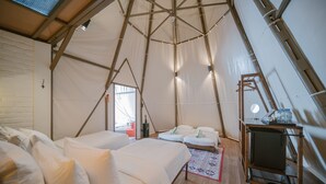 A tented accommodation with two beds, a small table, and a TV. - The Anmon Resort Bintan (Bintan)