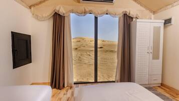 Une chambre avec une grande fenêtre, un lit, une armoire et un appareil de climatisation.