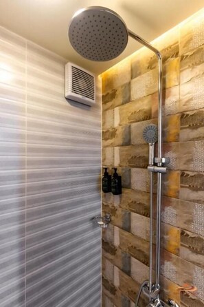 A shower with a rain showerhead, a handheld showerhead, and a wall-mounted air vent. - Desert Rose Village (Abu Dhabi)