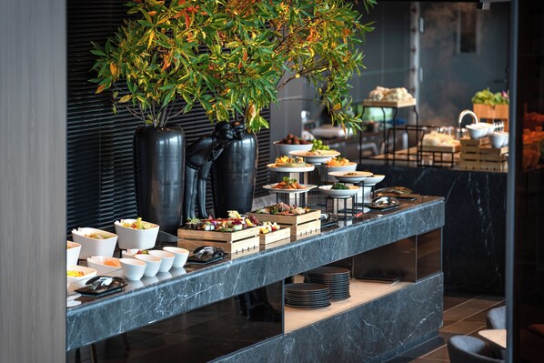 Un buffet con diversi piatti e una pianta decorativa.
