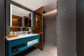 A modern bathroom with a large mirror, a blue vanity, and a walk-in shower. - Pagoda Hotel Chongqing Near By Liziba Hongya Cave (Chongqing)