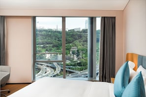 A hotel room with a large window offering a view of a highway and cityscape. - Pagoda Hotel Chongqing Near By Liziba Hongya Cave (Chongqing)
