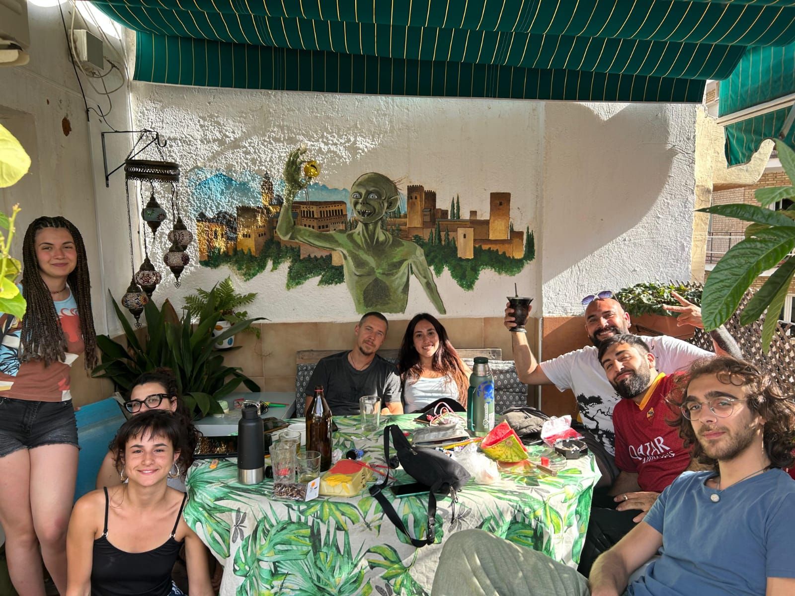 A group of people seated at a table with a cityscape mural in the background.