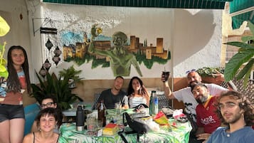 A group of people seated at a table with a cityscape mural in the background.