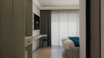 A modern hotel room with a bed, a desk, and a TV.