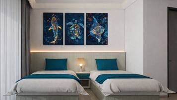 A hotel room with two beds, a nightstand, and three wall-mounted artworks depicting marine life.