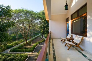 A balcony with a view of a landscaped garden and a pathway.
