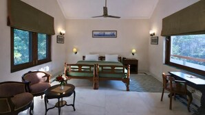 Une pièce comprenant un lit, deux chaises, un bureau et un ventilateur de plafond.