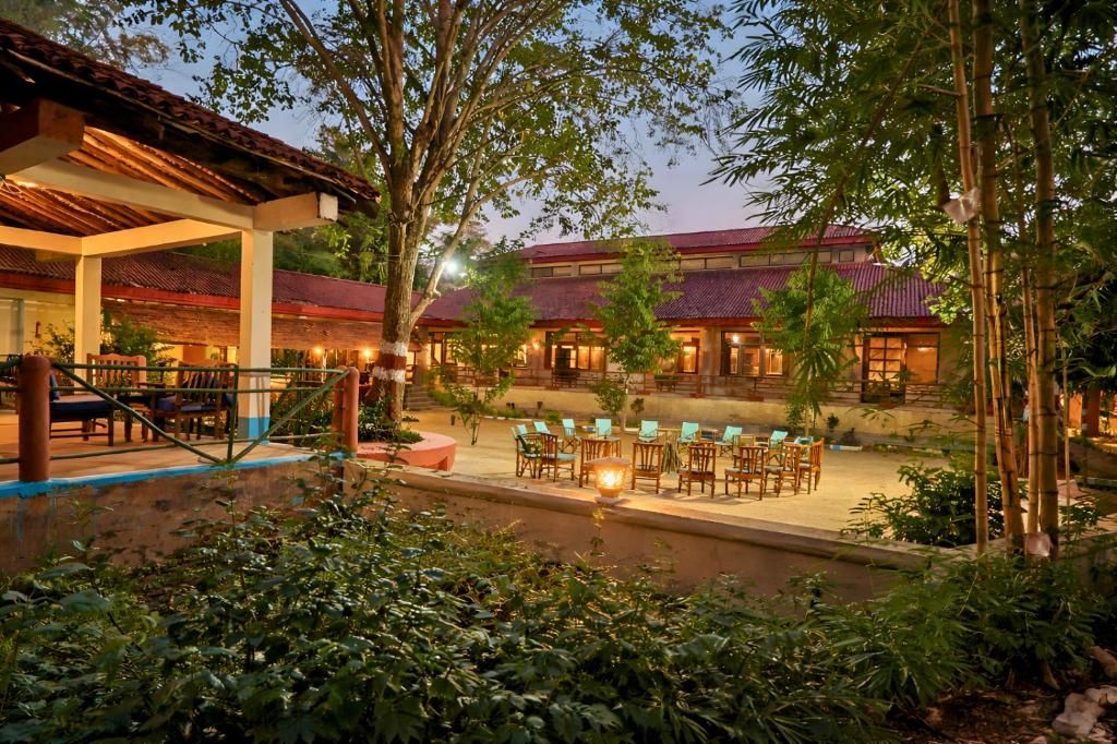A traditional building with a tiled roof, surrounded by lush greenery and outdoor seating areas.