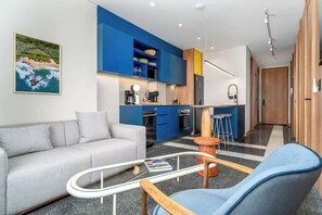 Un salon moderne avec un canapé, une table basse et un fauteuil bleu.