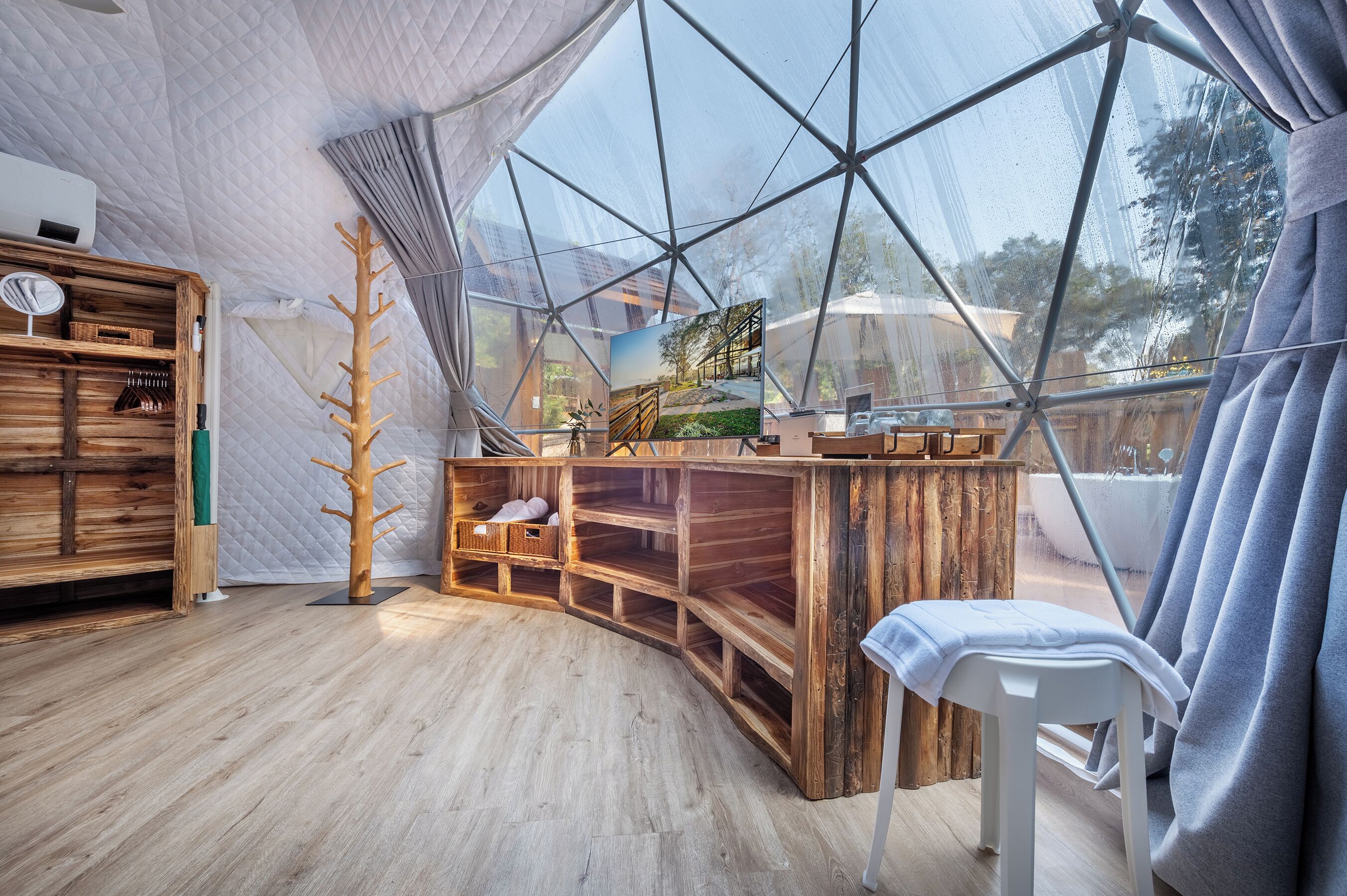 Una stanza moderna con arredamento open space, una grande vetrata, mobili in legno e un piccolo angolo salotto.