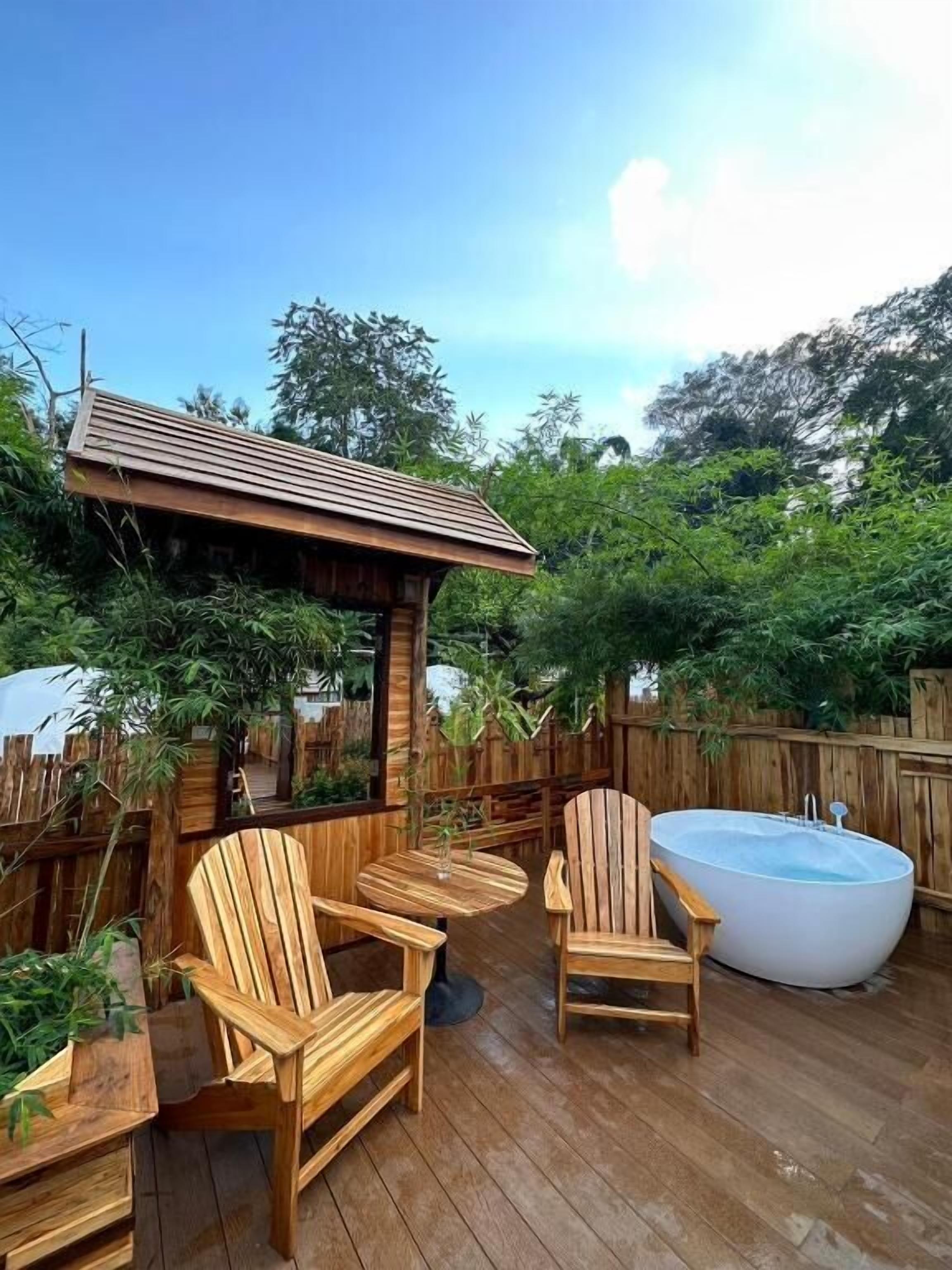 A wooden deck with outdoor seating and a hot tub.