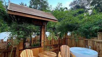 A wooden deck with outdoor seating and a hot tub.